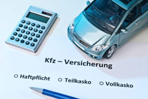Auto mit Rechner und der Schrift KFZ-Versicherung