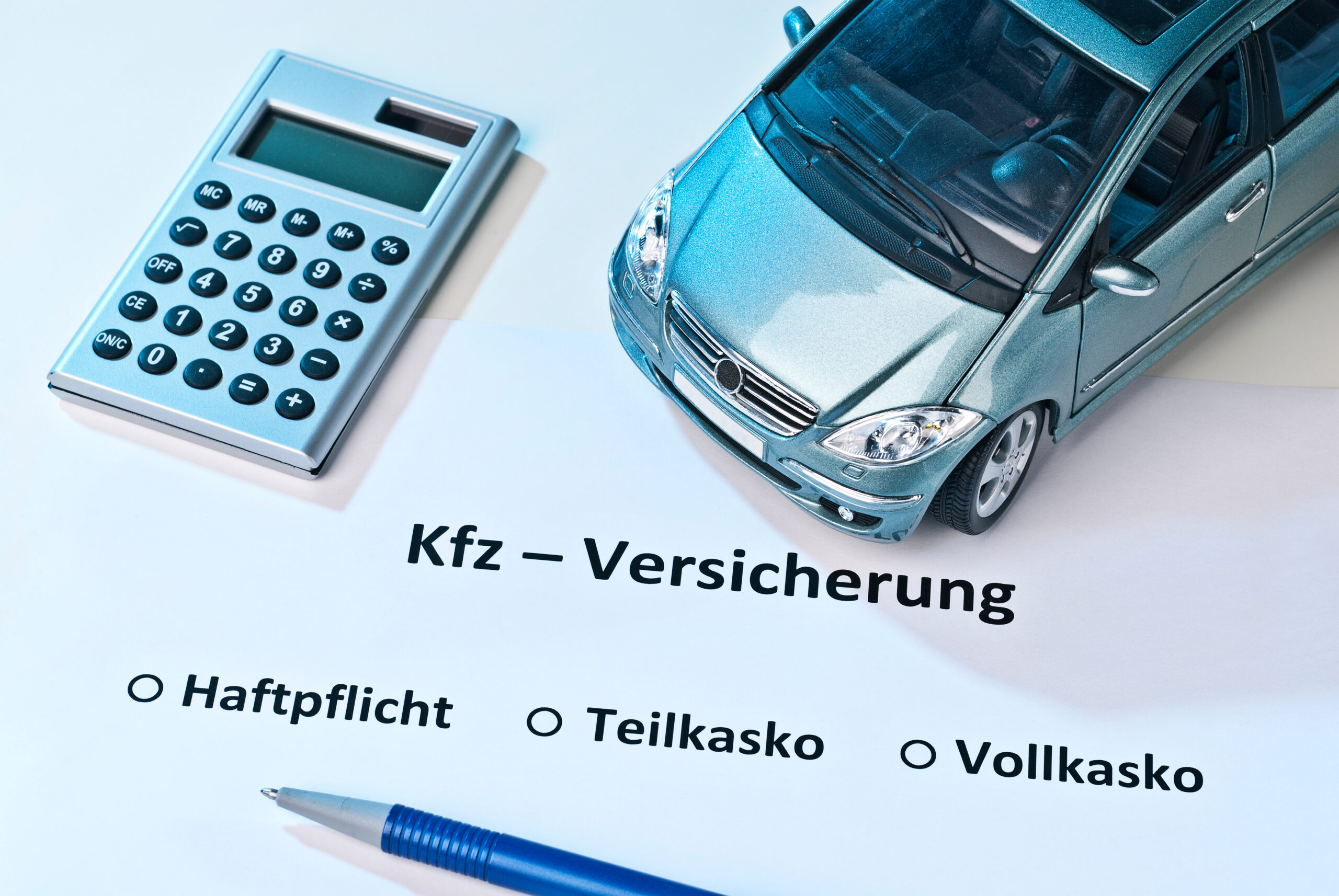 Auto mit Rechner und der Schrift KFZ-Versicherung